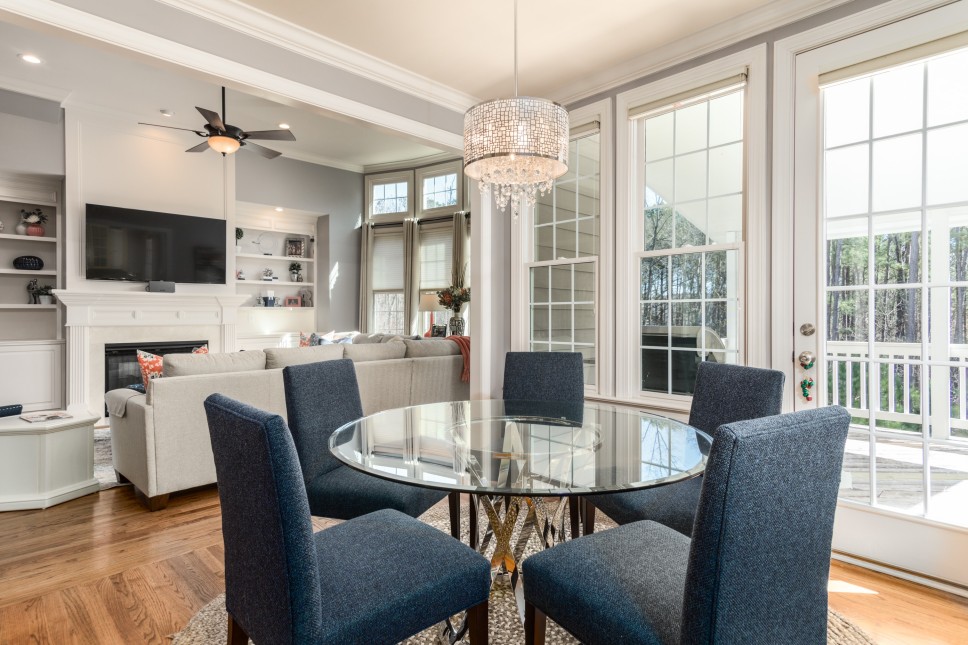 Image of a glass dining room table and chairs set up next to the patio
